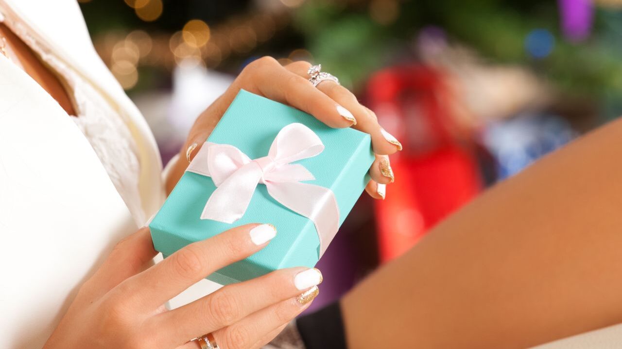 woman holding jewelry box with Christmas background credit Shutterstock