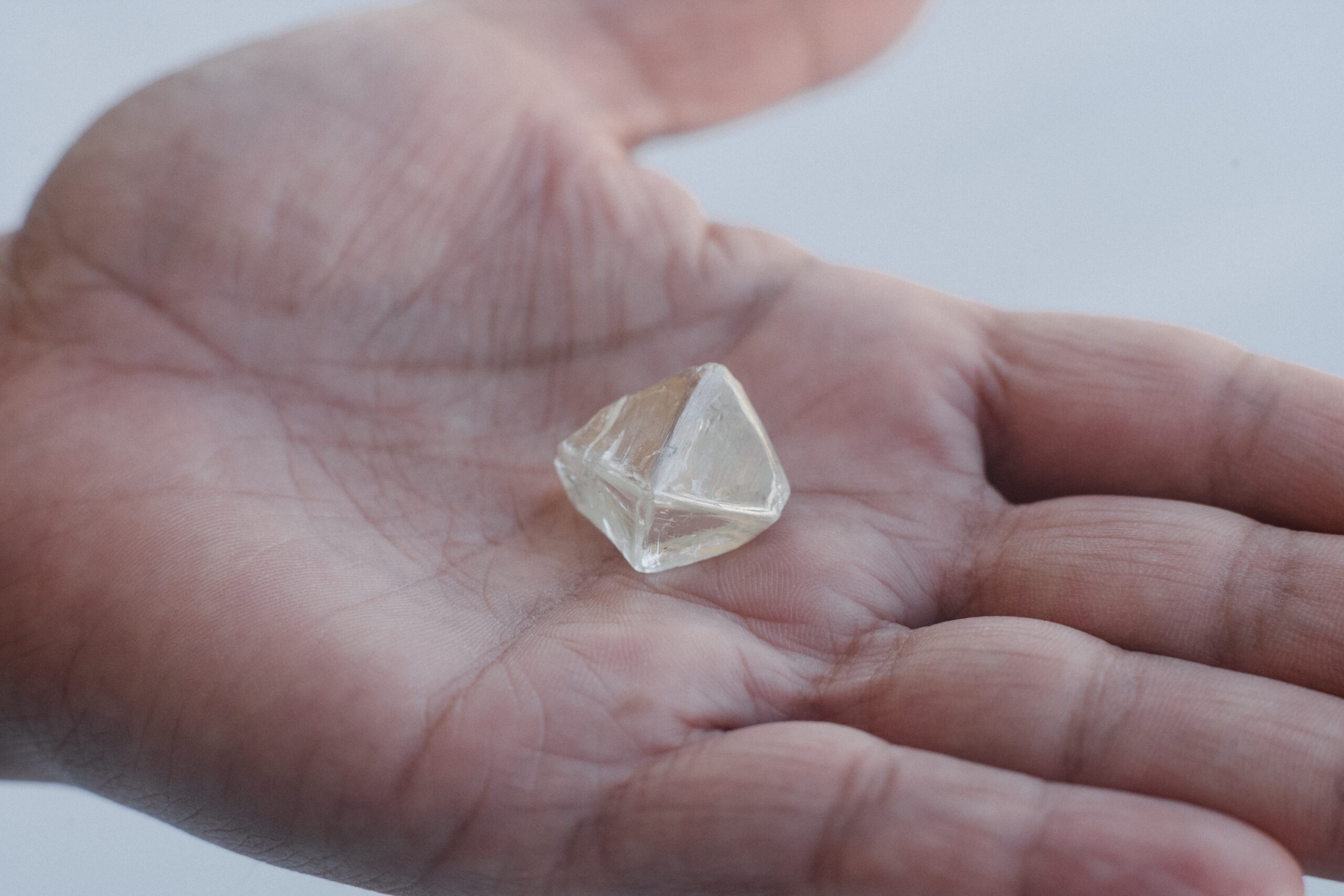 Employee holding rough diamond in palm of hand, Kimberley, DBSSSA Building, Kimberley, South Africa credit Ben Perry slash Armoury Films slash De Beers USED 042124 1280