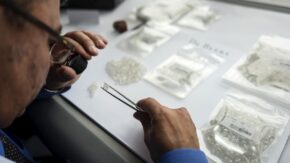 A De Beers Sightholder examining rough diamonds Botswana image