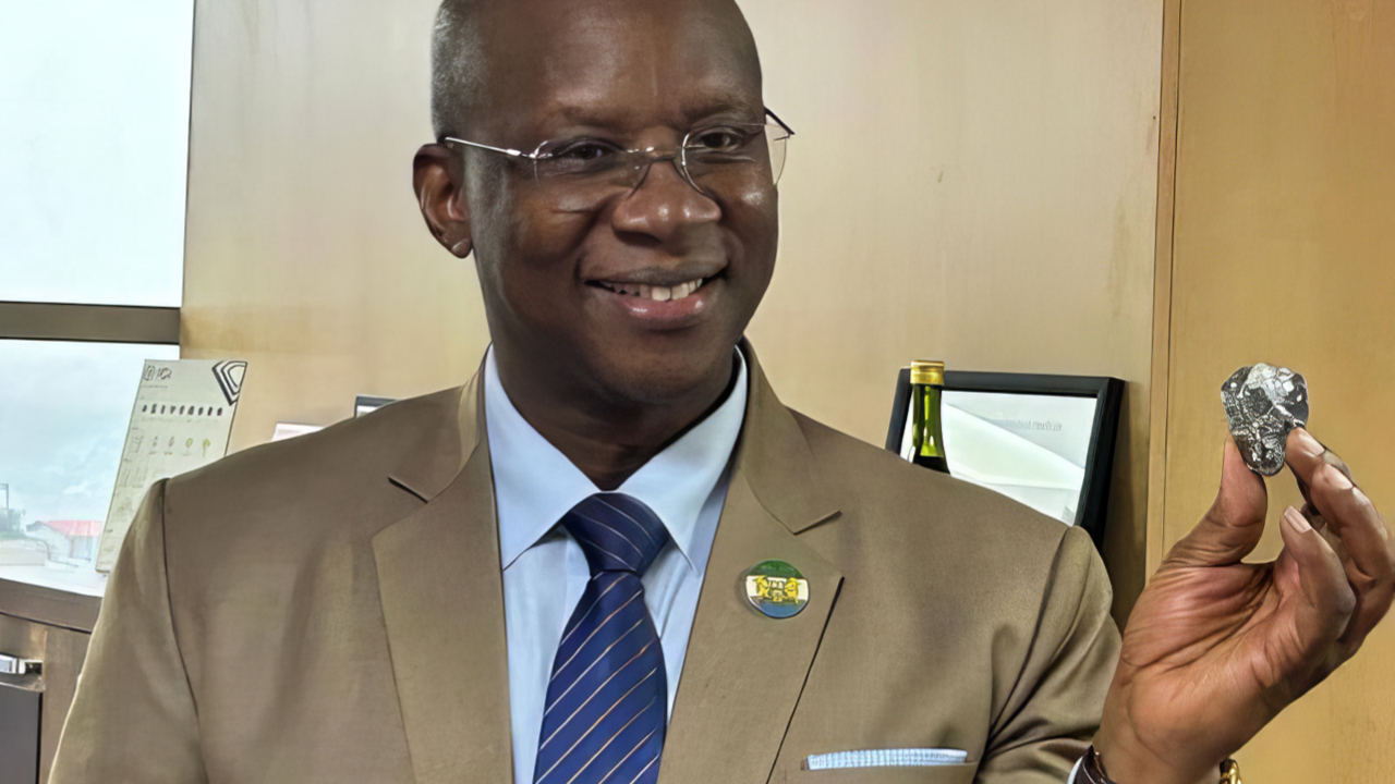 The minister of mines and mineral resources for Sierra Leone holding the 391.45-carat diamond image