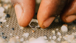 Hand picking up a rough diamond image