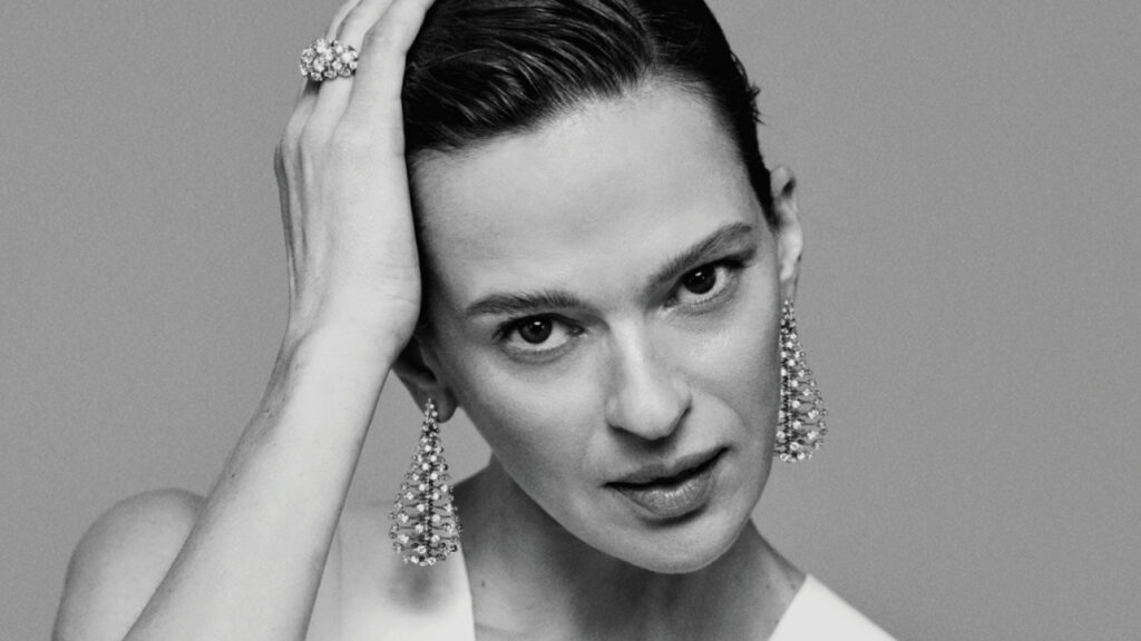 Model wearing Nikos Koulis Wish earrings and ring in 18-karat gold with diamonds image