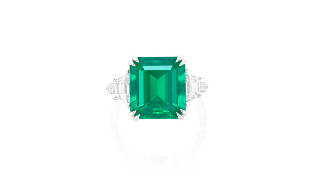 This ring contains a step-cut, 7.15-carat Colombian emerald between two trapeze-cut diamonds image
