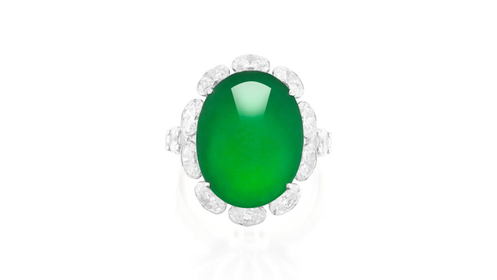 Ring sporting an oval, emerald-green jadeite cabochon with an oval-diamond surround and shoulders and a gallery decorated with brilliant-cut diamonds at Phillips image