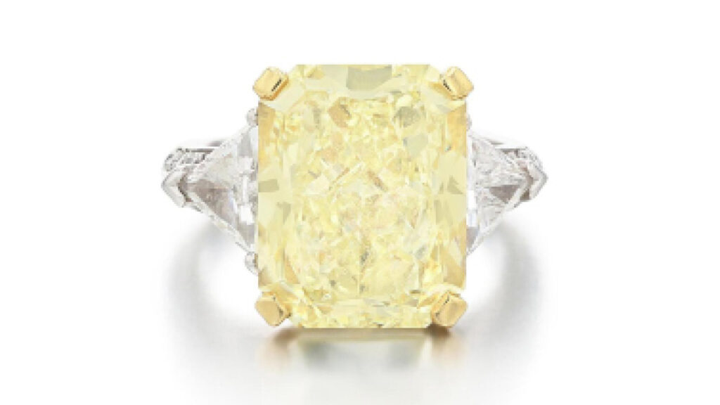 This Graff diamond ring carries a radiant-cut, 10.03-carat, fancy-light-yellow stone between two triangular-cut diamonds by Sotheby's image