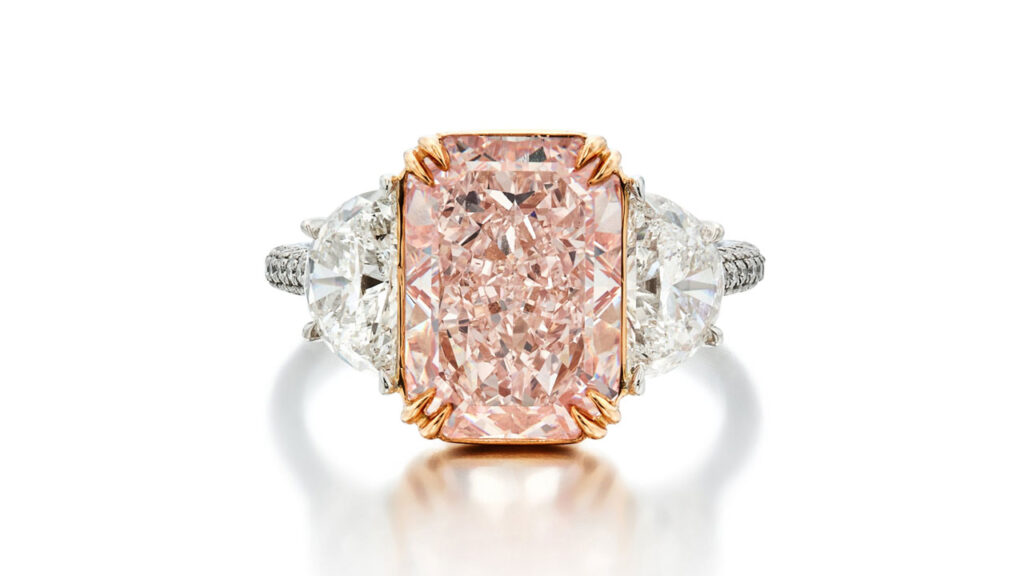 A ring with a cut-cornered, mixed-cut, fancy-pink diamond, flanked by two half-moon shaped diamonds at Sotheby's image