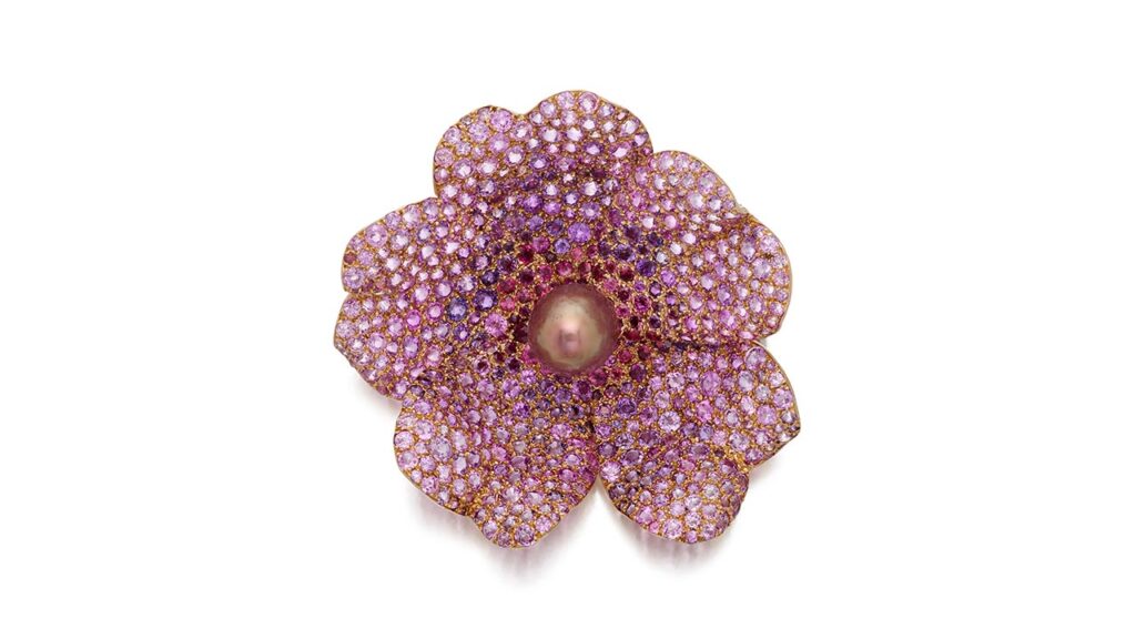 This JAR clip-brooch is designed as a wild rose pavé set with round, pink and purple sapphires and garnets, centering an ovoid pearl at Sotheby's image