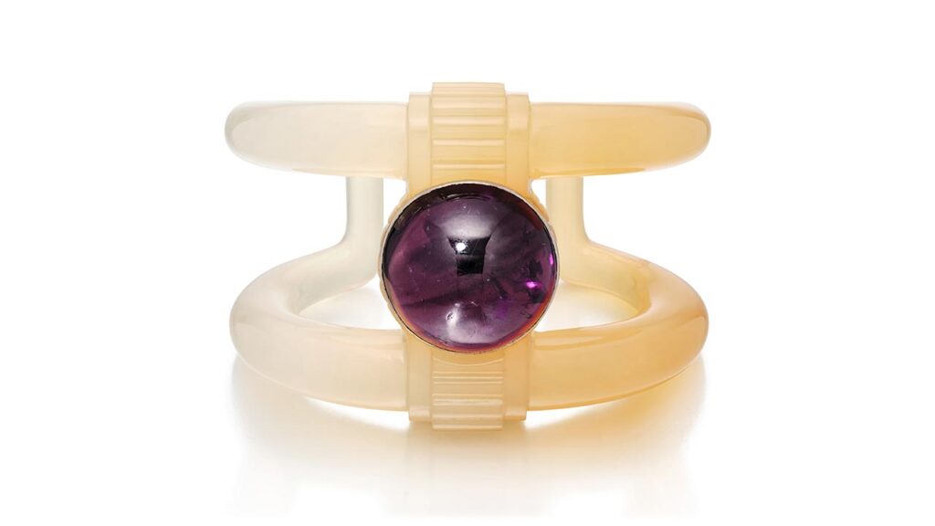 Suzanne Belperron cuff carved of bi-tone chalcedony and sports a round amethyst cabochon at Sotheby's image