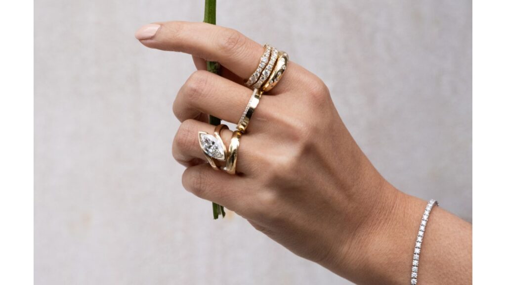 A model wears a selection of rings and a bracelet by The Clear Cut image