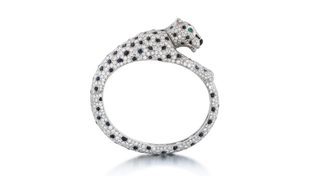 A piece by Cartier is this bangle, designed as a panther. It contains sapphire spots and brilliant-cut diamonds, while the eyes are set with pear-shaped emeralds and it has an onyx nose at Sotheby's image