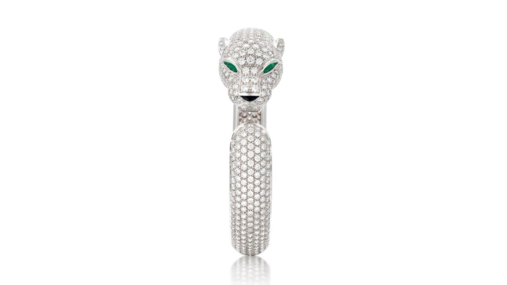 A Cartier panther bangle contains a total of 11 to 13 carats of diamonds of F to G color and VVS to VS clarity. It has pear-shaped, slightly bluish-green emeralds for eyes and an onyx nose at Sotheby's image