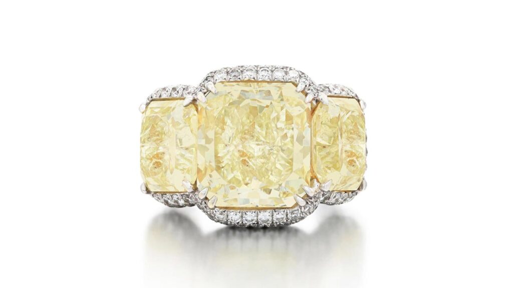 Crafted by Schreiner, this ring features a central cut-cornered rectangular, 12.07-carat, fancy-yellow diamond with a 5.35-carat, fancy-light-yellow diamond and a 5.33-carat, fancy-yellow diamond of the same cut on either side at Sotheby's image