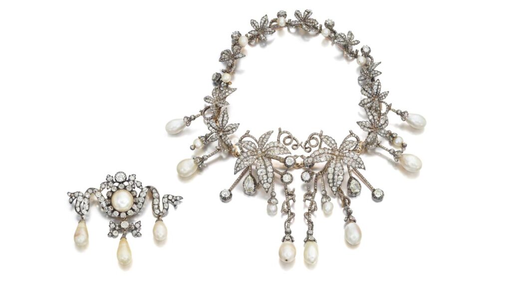 Comprising a transformable jewel designed as a graduated garland of vines, this piece contains old mine-cut diamonds set throughout, as well as rose-cut diamond accents, and suspends drop-shaped and slightly baroque-shaped natural pearls. It can create two brooches, six hairpins and two tiaras. The jewel is part of a set with a brooch designed as a ribbon and featuring old mine-cut diamonds and a pearl. Coming from a European noble family, the pearls were initially the property of Prince Franz Xaver of Saxony and Poland, whose daughter was a cousin of King Louis VXI of France at Sotheby's image