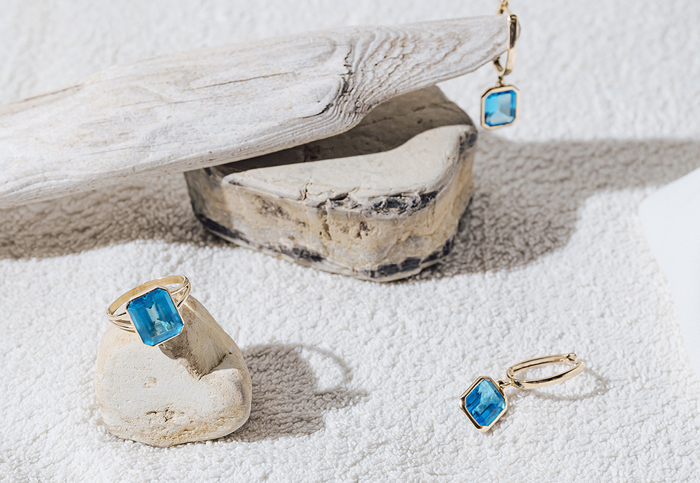 Matching earrings featuring blue topaz gemstones set in gold rings image