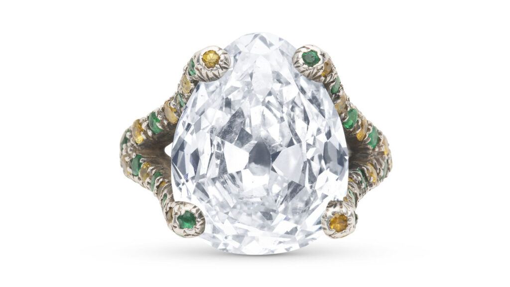 A pear-shaped modified brilliant-cut, 9.45-carat, I, SI2 diamond is the highlight of this ring, with added round emeralds and colored sapphires on the band at Christie's image