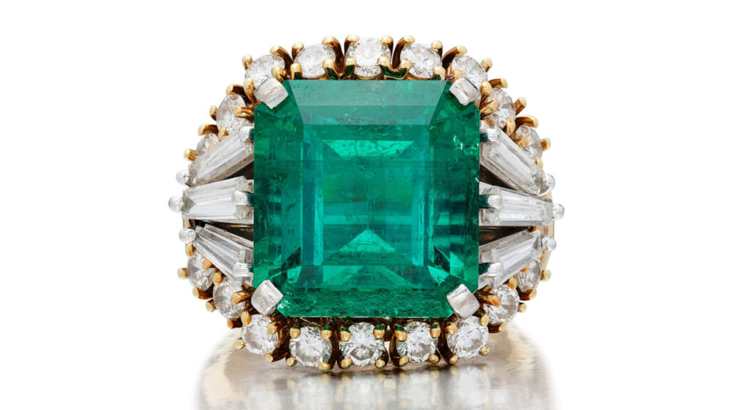 This ring centers a square emerald-cut Colombian emerald between tapered baguette diamonds and comes with a ring jacket of round diamonds at Sotheby's image