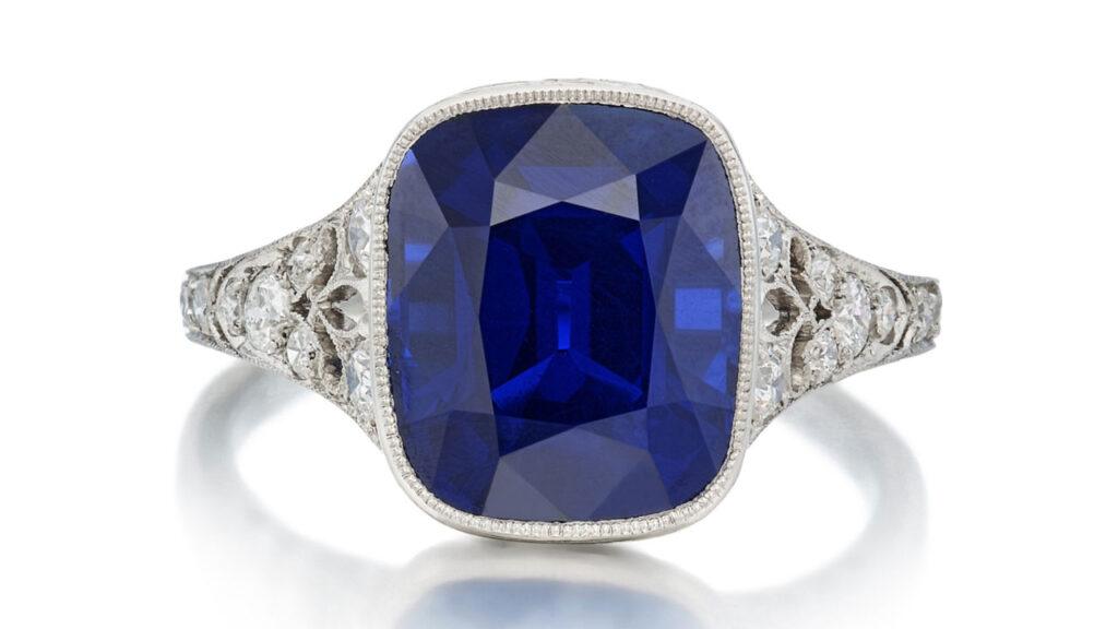 This Tiffany & Co. ring bears a cushion-shaped, 5.61-carat Kashmir sapphire, with round-diamond accents and fleur-de-lis motifs on the shoulders at Sotheby's image