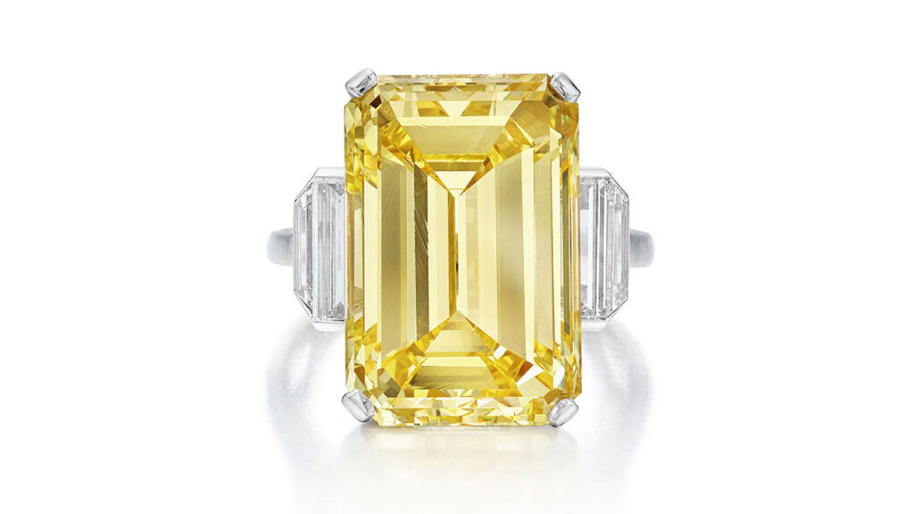 This ring featuring an emerald-cut, 18.18-carat, fancy-intense-yellow diamond between baguette and trapezoid-shaped diamonds at Sotheby's image