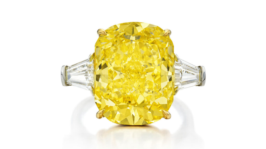 Bulgari ring bears a round-cornered rectangular modified brilliant-cut, 12.51-carat, fancy-vivid-yellow, internally flawless diamond between two tapered baguette diamonds at Sotheby's image