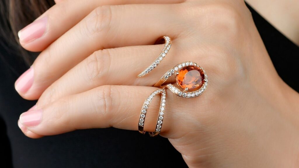 Lionheart two-finger Wildflower cocktail ring in 18-karat gold with diamonds and a spessartite garnet image