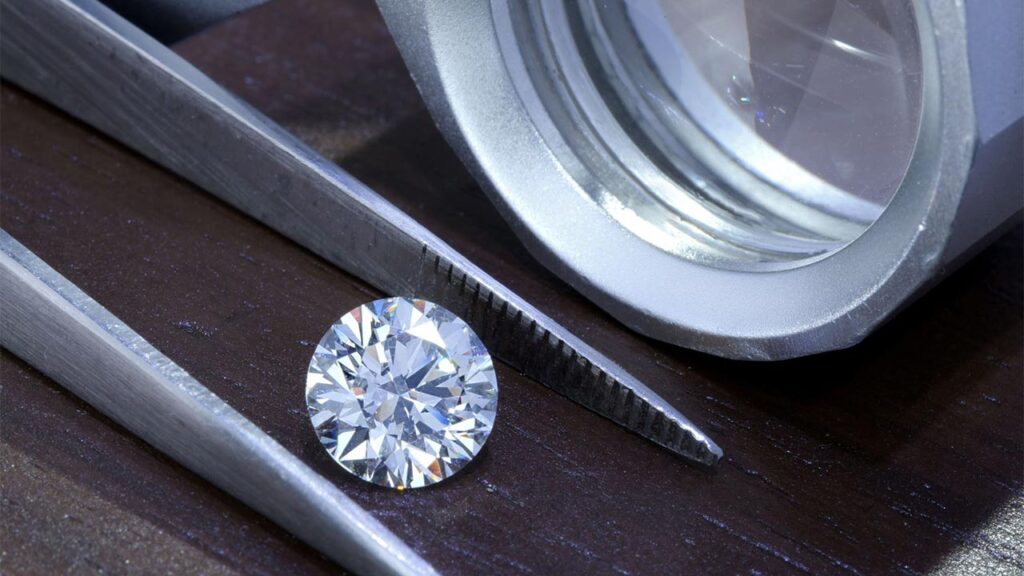 A polished diamond in tweezers image