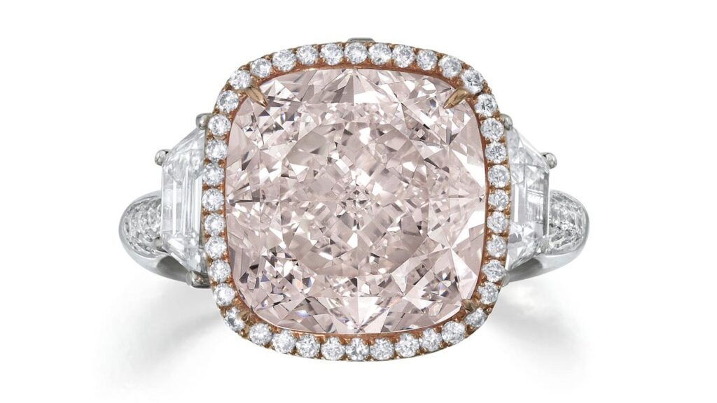 This ring features a cushion-cut, 8.23-carat, faint-pink, internally flawless diamond in a round brilliant-cut diamond frame, flanked by two trapezoid-shaped stones at Bonhams image