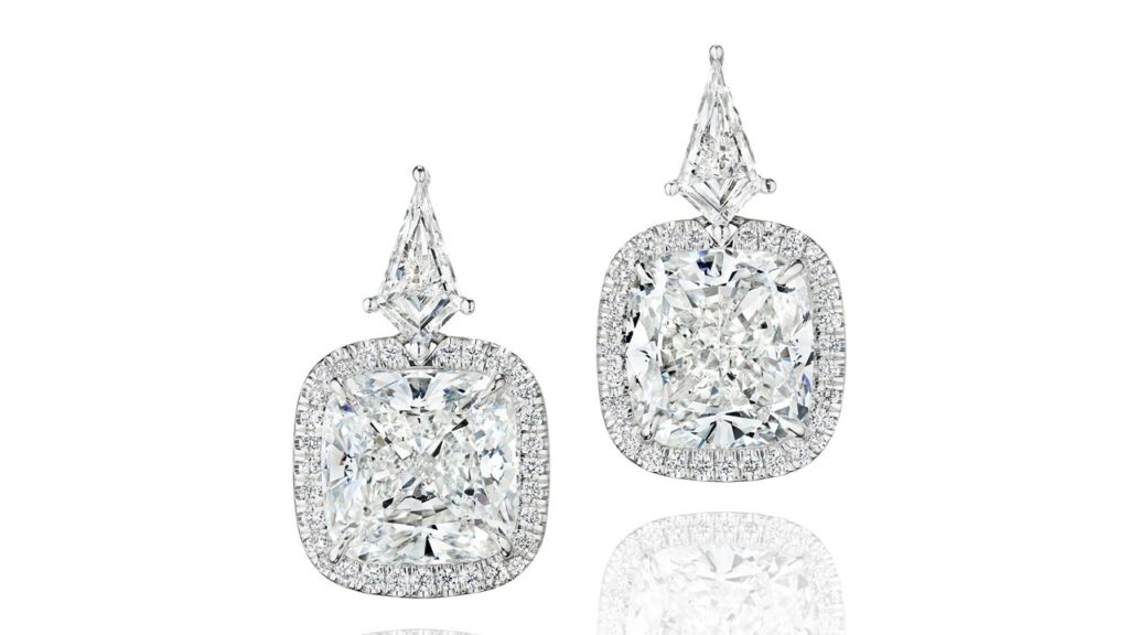 A pair of earrings, each sporting a cushion-cut, 5.01-carat, E, VS1 diamond within a surround of round brilliant-cut stones, suspended from a kite-shaped diamond at Bonhams image