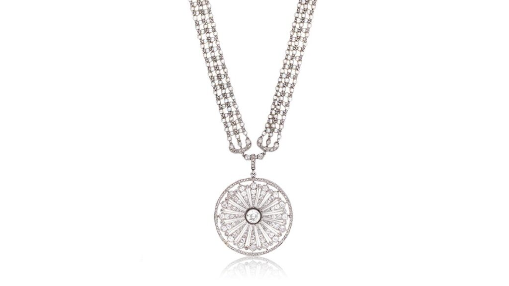 A Cartier Belle Époqueseed pearl and diamond sautoir from around 1910 belonged to the opera singer Dame Nellie Melba (1861-1931). The necklace sports a circular pendant, pierced with a radiating floral motif, millegrain-set with similarly cut diamonds. The chain features seed-pearl linking, accented at intervals by scroll and floral spacers millegrain-set with old brilliant-, old single- and rose-cut diamonds at Bonhams image