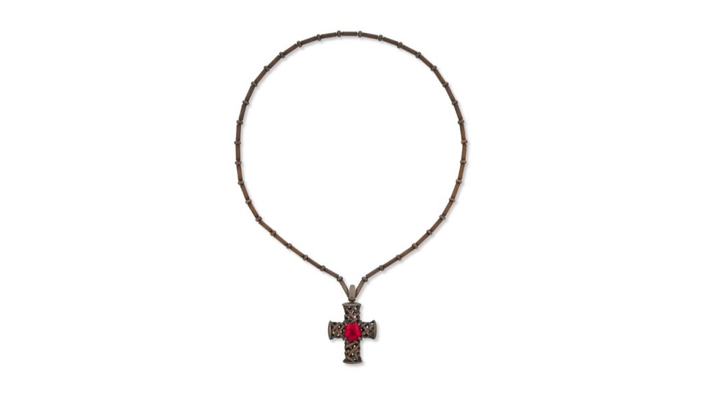 A Hemmerle necklace featuring a cushion-shaped, 10.25-carat Tanzanian red spinel in the center of a copper cross at Christie's image