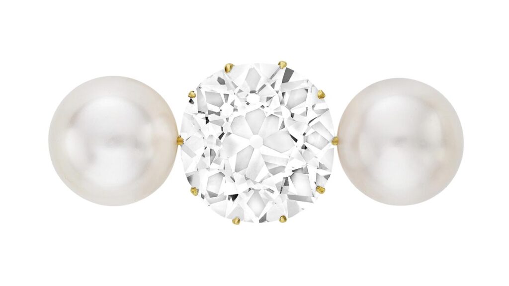A brooch designed circa 1900, featuring an old mine brilliant-cut, 18.27-carat, D, SI1 diamond between two button-shaped natural pearls at Christie's image
