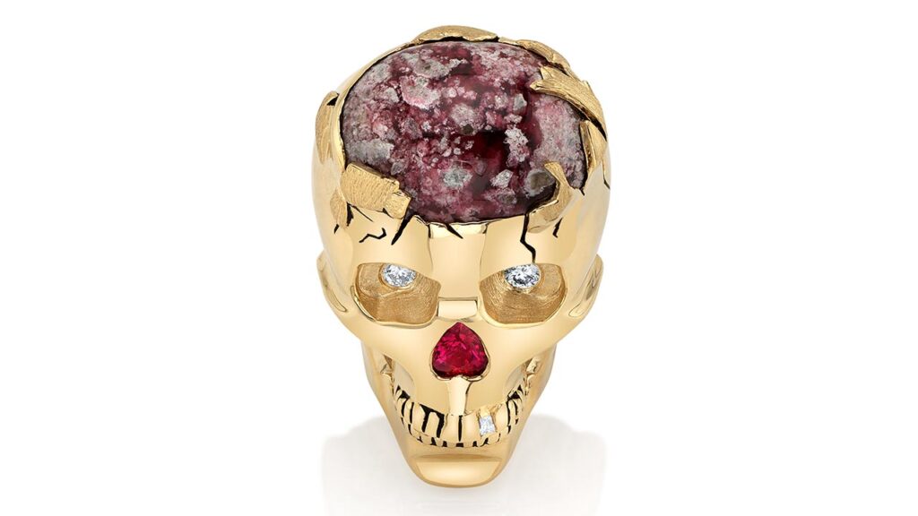 A 14-karat yellow gold skull brooch with 7.14 carats of red beryl cabochon, a heart-shaped, 0.21-carat ruby, and baguette and round brilliant diamonds, Jewelers of America image
