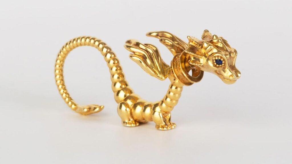 La Dragonne, a long three-finger ring and sculpture in sterling silver with 18-karat yellow gold plating featuring blue sapphire eyes, Jewelers of America image