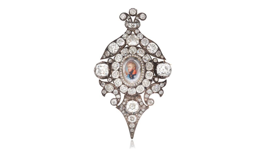 A jewel featuring a watercolor portrait of Emperor Alexander I of Russia, from around 1810, designed by Sidmouth. The portrait is topped by a portrait-cut diamond, in a closed-back rose-cut diamond setting. It was later set within a surround of old brilliant and old cushion-cut diamonds, featuring scroll and foliate motifs at Bonhams image