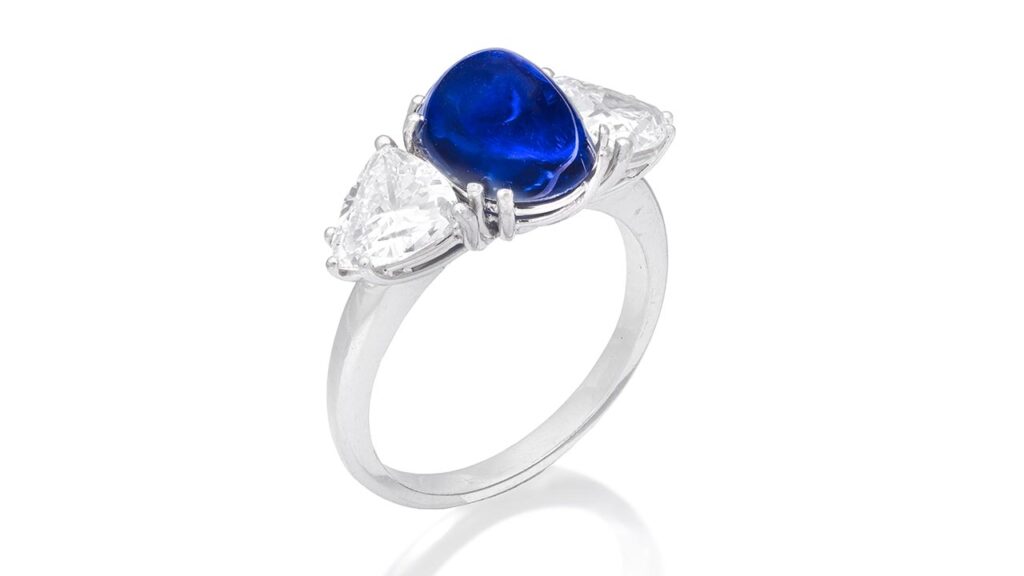 Bonhams is offering a ring starring a sugarloaf cabochon, 5.63-carat Kashmir sapphire, between two trilliant-cut diamonds at Bonhams image