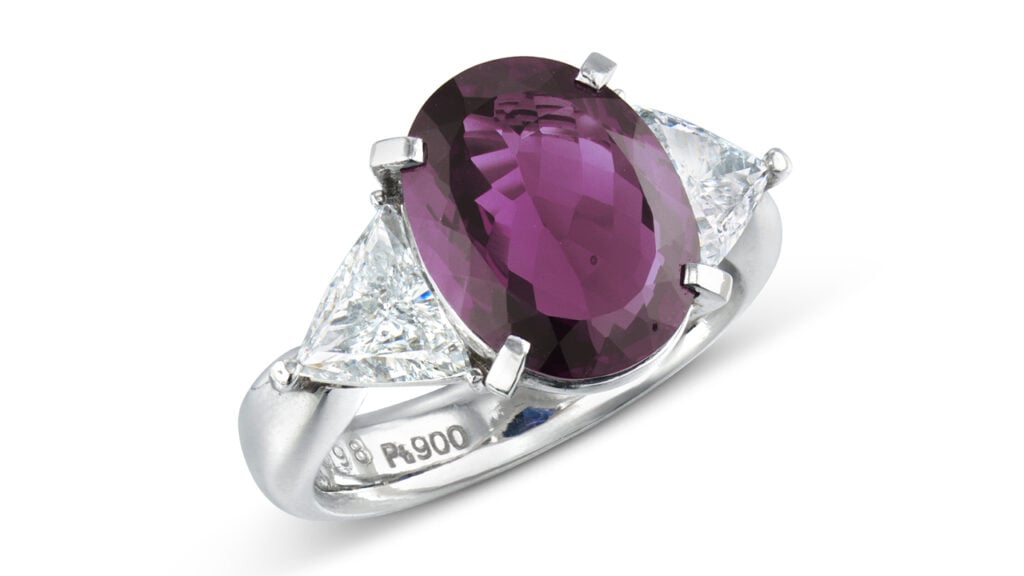 A ring centering an oval-shaped, 4.14-carat Brazilian alexandrite with trilliant-cut diamonds on each side at Christie's image
