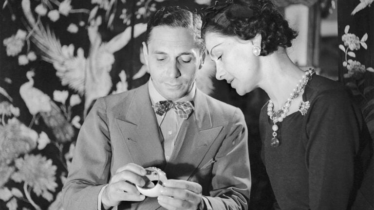 Fulco di Verdura poses with Coco Chanel in Paris 1937 while admiring the Maltese Cross cuffs he designed for her image