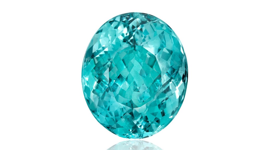 An unmounted oval-shaped, 30.61-carat Mozambique Paraíba-type tourmaline, accompanied by a hexagonal frame in a link necklace. The piece made six times its high estimate at Bonhams image