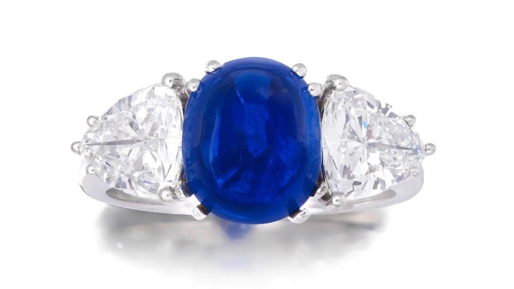 This ring stars a sugarloaf cabochon Kashmir sapphire weighing 5.63 carats and trilliant-cut diamond shoulders at Bonhams image