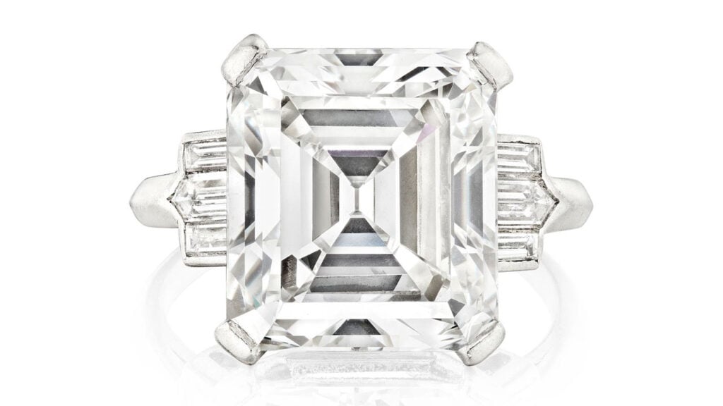 A ring starring an emerald-cut, 8.29-carat, G, VS1 diamond between two step-cut diamonds at Bonhams image