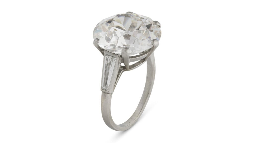 A ring with a round, 11.51-carat, I, SI1 diamond between trapeze baguette-cut diamonds at Christie's image