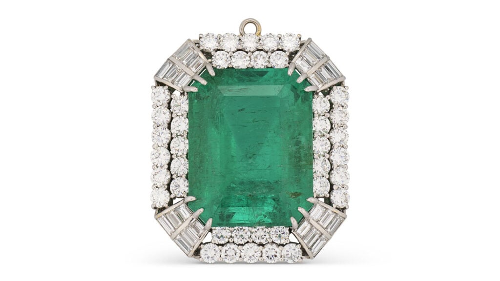 A pendant centering a rectangular Colombian emerald in a circular- and baguette-cut diamond surround at Christie's image