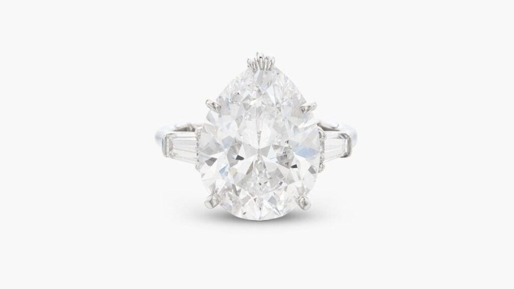 A Harry Winston ring bearing a pear-shaped, 6.72-carat, D, VS2 diamond between a pair of tapered-baguette diamonds at Sotheby's image