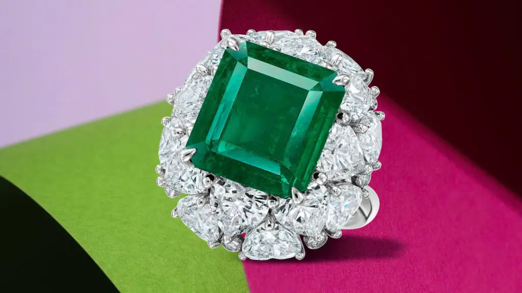 A ring starring a step-cut, 5.84-carat Colombian emerald in a heart-shaped and round brilliant-cut diamond surround at Bonhams image