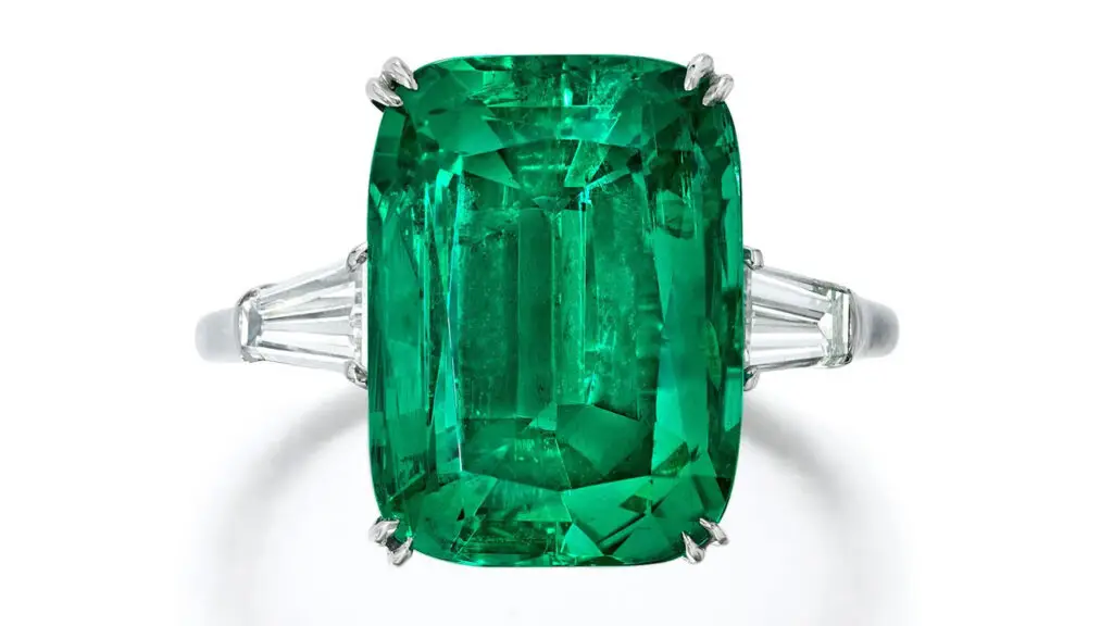 This Harry Winston ring centers a cushion-cut, 7.08-carat Colombian emerald between tapered baguette-cut diamonds at Bonhams image