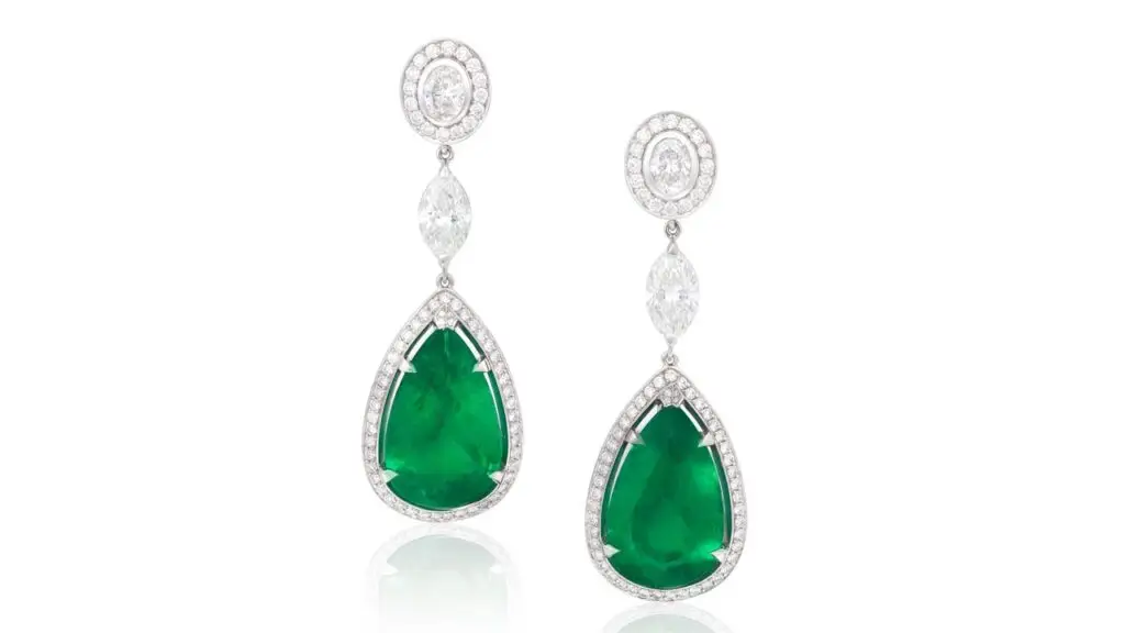 A pair of earrings featuring pear-cut Colombian emeralds weighing 15.29 and 15.76 carats in pavé-set brilliant-cut diamond surround, suspended from brilliant and oval-cut diamond surmounts at Bonhams image