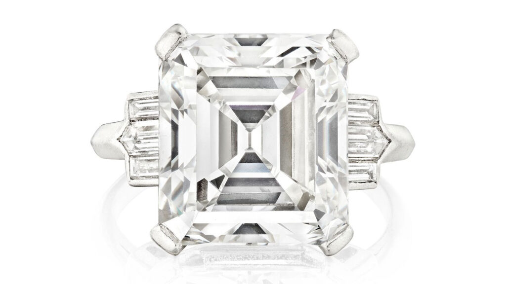 A ring starring an emerald-cut, 8.29-carat, G, VS1 diamond between two step-cut diamonds at Bonhams image