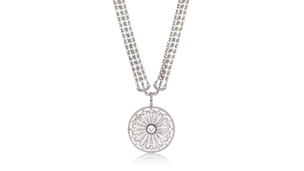 A Cartier Belle Époqueseed pearl and diamond sautoir from around 1910 belonged to the opera singer Dame Nellie Melba (1861-1931). The necklace sports a circular pendant, pierced with a radiating floral motif, millegrain-set with similarly cut diamonds. The chain features seed-pearl linking, accented at intervals by scroll and floral spacers millegrain-set with old brilliant-, old single- and rose-cut diamonds at Bonhams image