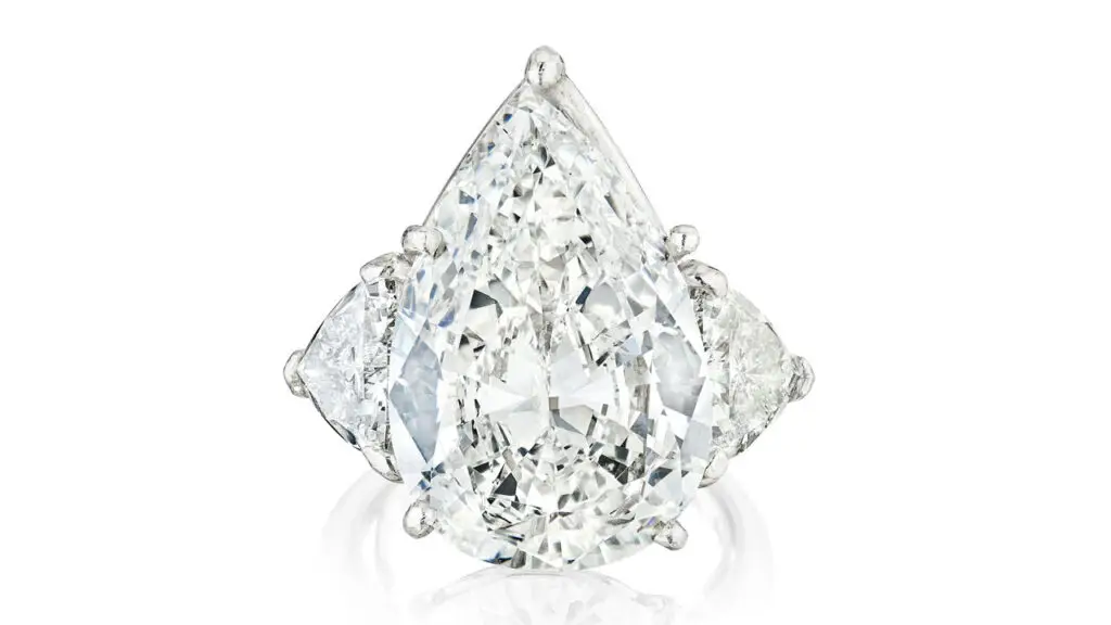 This ring features a pear-shaped, 11.42-carat, G, SI2 diamond between two trilliant-cut diamonds at Bonhams image