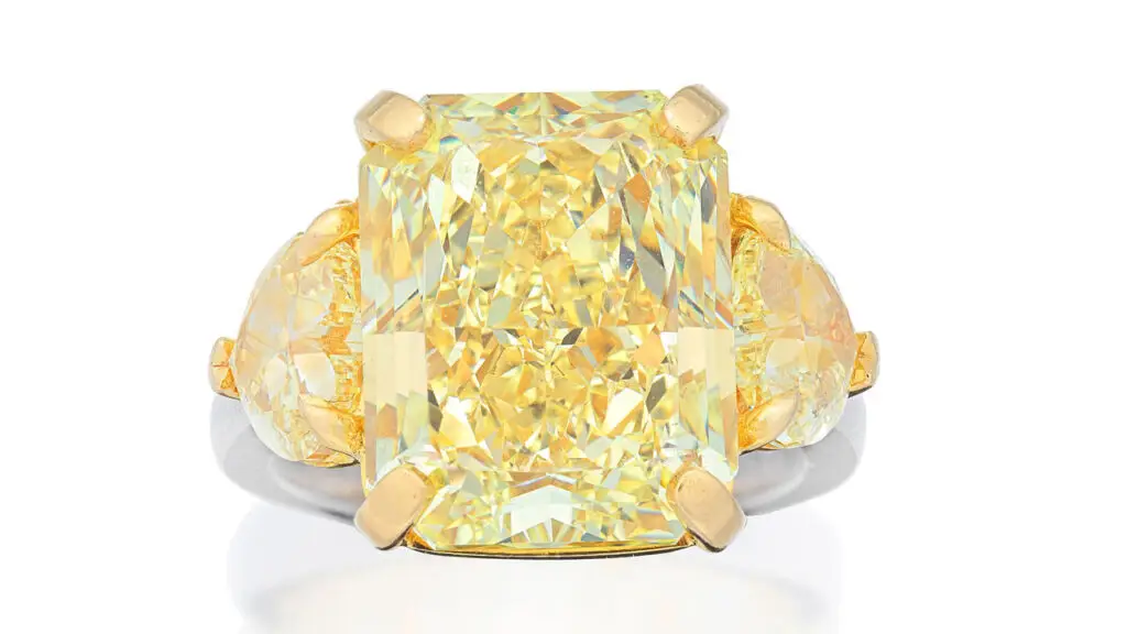 This ring centers a radiant-cut, 12.38-carat, fancy-yellow, VS2-clarity diamond between two heart-shaped, fancy-light-yellow diamonds weighing 1.12 and 1.52 carats respectively at Bonhams image