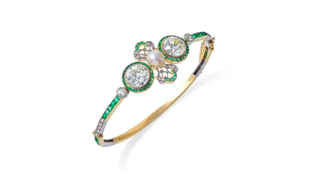 This bracelet bears a cultured pearl between two brilliant-cut diamonds — a 3.22-carat, N to R color and a 3.32-carat, N to R color stone. Also featuring calibré-cut emeralds and rose-cut diamonds at Bonhams image